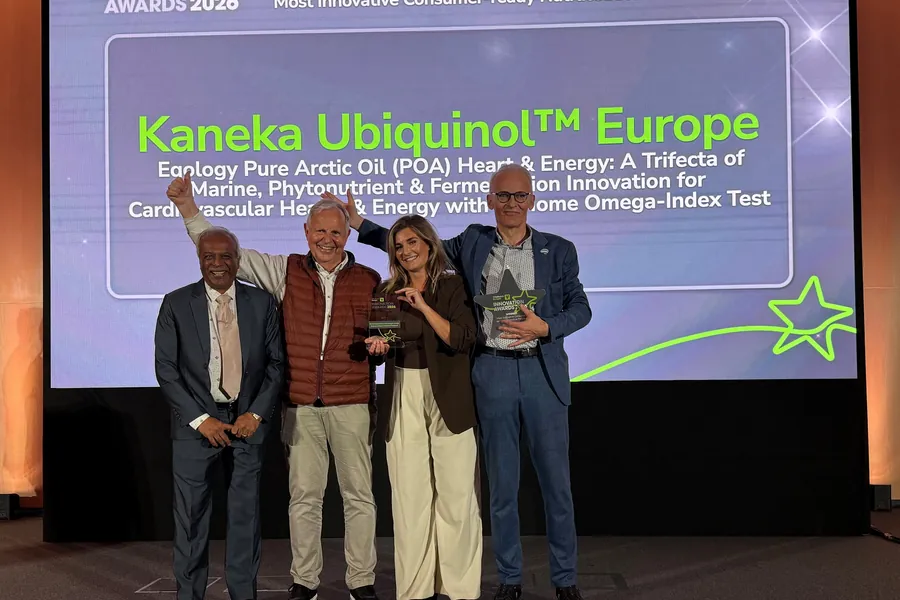 three men and a woman on stage hold award smiling